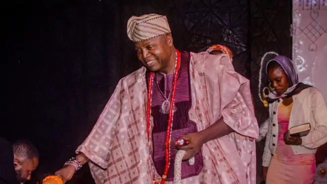 Ọba Adeyemi Adediran Owamiran nibi eto kan, o wọ agbada ati fila pẹlu akun lọrun ati ọwọ rẹ