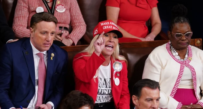 Taylor Greene Kongre'deki bir oturumda MAGA şapkası takıyor ve elini kaldırmış bir tepki gösteriyor