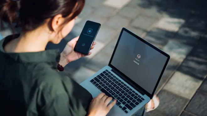 File image of woman with phone and laptop