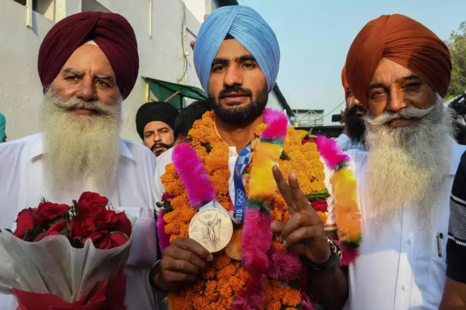 टोक्यो ओलंपिक खेलों में कांस्य पदक जीतने वाली टीम का हिस्सा थे पंजाब के गुरजंट सिंह (बीच में, मेडल के साथ). यहां 11 अगस्त 2021 में वे अमृतसर पहुँच कर फ़ख़्र से अपना मेडल दिखाते हुए. 