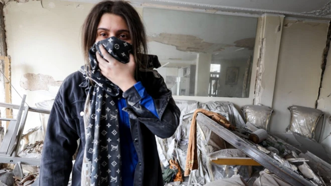 İran'ın başkenti Tahran'da, bir hava saldırısının ardından hasar gören dairesini inceleyen bir kadın