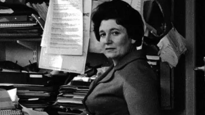 Diane Munday, sitting at a desk in the 1960s