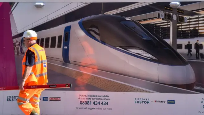 A worker walks outside the HS2 construction site at Euston Station in London