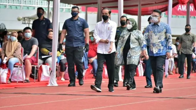 Presiden Joko Widodo (kiri) didampingi Gubernur Jawa Barat Ridwan Kamil (kanan) dan Bupati Bogor Ade Yasin (tengah) meninjau vaksinasi massal di Stadion Pakansari, Cibinong, Kabupaten Bogor, Jawa Barat, Kamis (17/06).