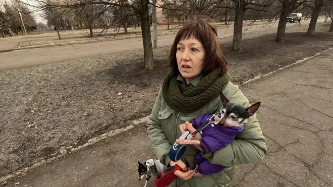 Жена држи пса у руци