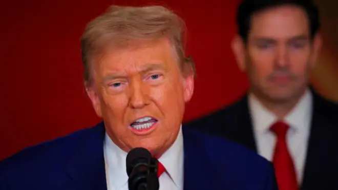 Predsednik SAD Donald Tramp priča ispred mikrofona, iza njega državni sekretar Marko Rubio