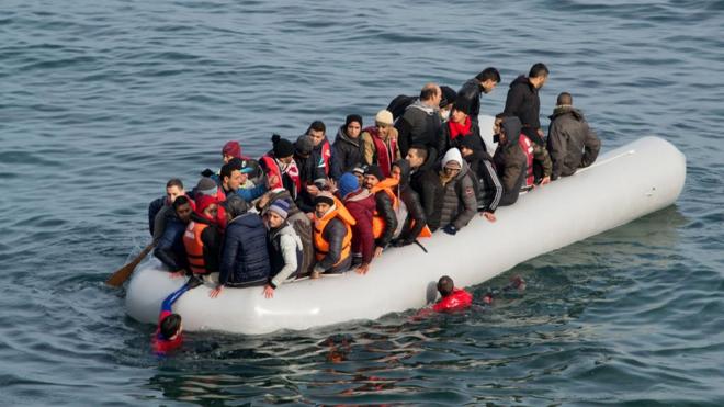 Refugees and migrants arrive in an overloaded rubber dinghy on the Greek island of Lesbos