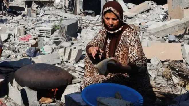  İsrail saldırılarında yıkılan evlerinin yakınlarında ekmek pişiren Filistinliler
