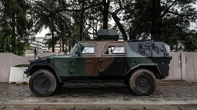 Un véhicule blindé est positionné à l'entrée d'une route bloquée à côté de la télévision nationale, Bénin TV, à Cotonou, le 8 décembre 2025.
