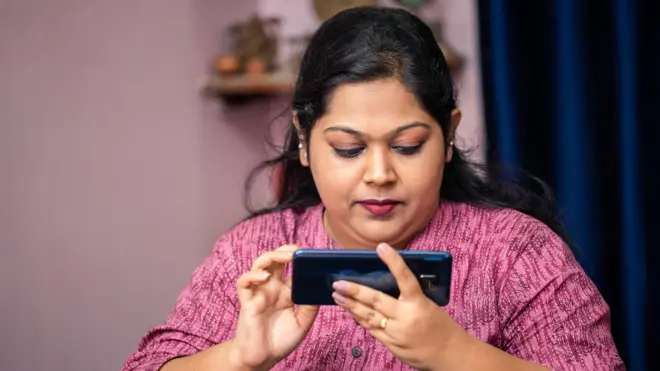 మొబైల్ చూస్తున్న మహిళ