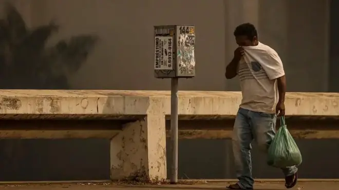 Homem cobre o rosto com camisacasa de apostas valor minimoBrasília