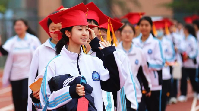 Senior three students from Rizhao Experimental High School don red mortarboards as they take part in the school's graduation ceremony on 16 May, 2025 in Rizhao, Shandong