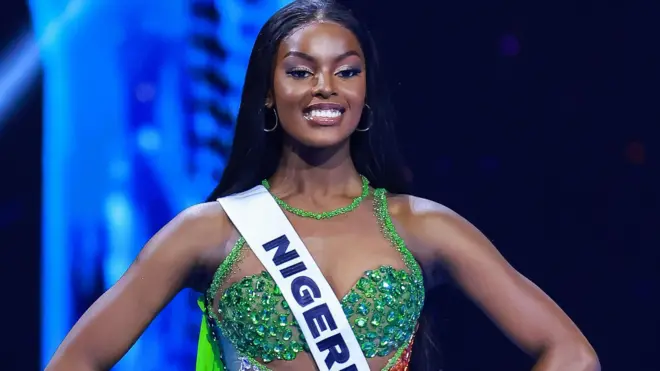 Chidimma Adetshina yambaye isutiye (soutien-gorge) ibengerana y'icyatsi kibisi n'igitambaro yiteye ku rutugu cyanditseho Nigeria, ubwo yari ari mu irushanwa rya Miss Universe, mu mujyi wa Mexico, muri Mexique, ku itariki ya 16 Ugushyingo (11) mu mwaka wa 2024. 