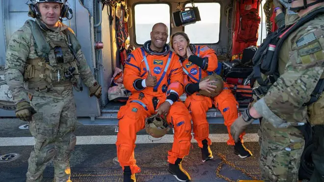 Los tripulantes Christina Koch y Victor Glover sonríen a bordo de un buque de rescate tras ser extraídos de la cápsula de Artemis II en el océano Pacífico.