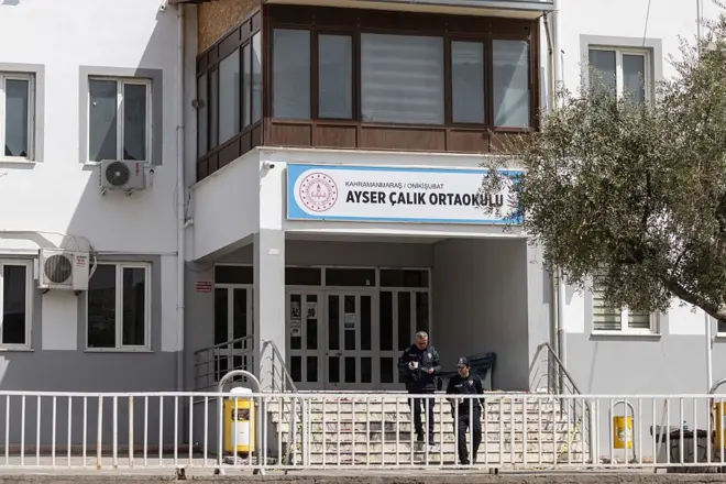Saldırının düzenlendiği Kahramanmaraş'taki Ayser Çalık Ortaokulu'nun merdivenlerinden iki polis memuru iniyor.