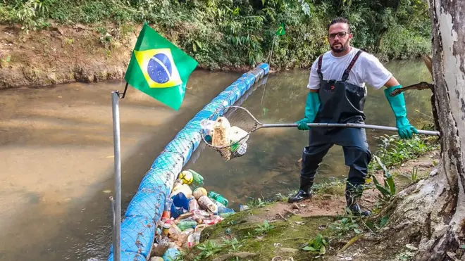 Vendedor gastou cercaplanilha controle apostasmil reais com a construção da barreira; ele mantém o rio limpo tirando o lixo acumulado na ferramenta que construiu