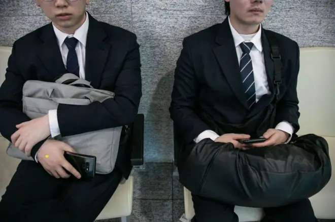 양복을 입고 면접 순서를 기다리는 구직자들 