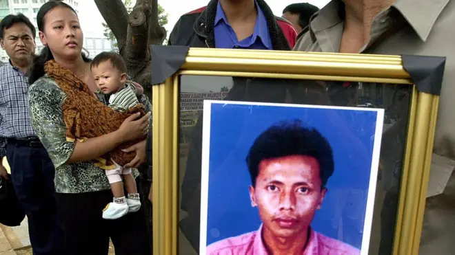 Mimin Sumiarti (kiri, menggendong anaknya yang bernama Adelia) mengenang suaminya, sopir taksi Eyo Zakaria, yang menjadi korban serangan bom JW Marriott, 12 Agustus 2003.