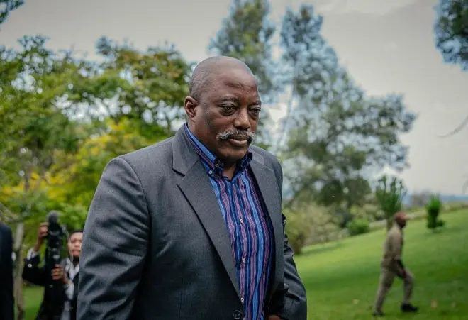 L'ancien président Joseph Kabila, rentre chez lui après avoir posé pour une photo de groupe avec des chefs religieux dans l'une de ses résidences à Goma, le 29 mai 2025. Il porte une chemise rayée et une veste sombre. 