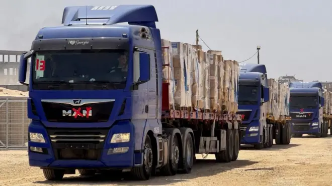Camiones de la GHF entregando alimentos a sus "Sitios de Distribución Segura" el lunes.