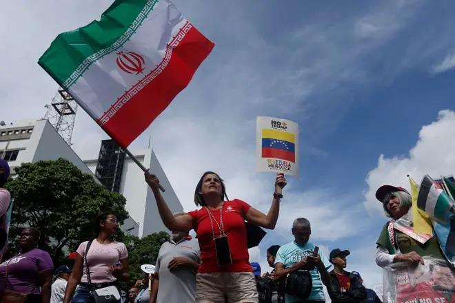 Una mujer ondea la bandera de Irán durante una manifestación contra los ataques de Israel a ese país en Caracas