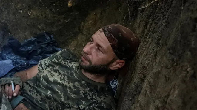 Український військовий відпочиває в окопі на лінії фронту на Донеччині.