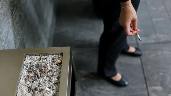 건물 앞 담배를 피는 여성