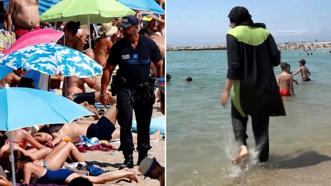 Cannes sahillerinde bir plajda devriye gezen polis ve haşemalı bir kadın