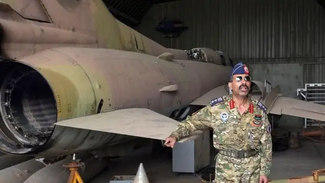 المتحدث باسم قوات الحكومة محمد قنونو بجوار طائرة من طراز ميغ-23 في قاعدة الوطية