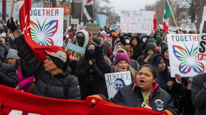 Minneapolis'te göstericiler 10 Ocak'ta ellerinde pankartlarla yürüyor. Pankartlarda "Birlik", "Renee için Adalet", "Asıl suç Beyaz Saray'da" yazıyor