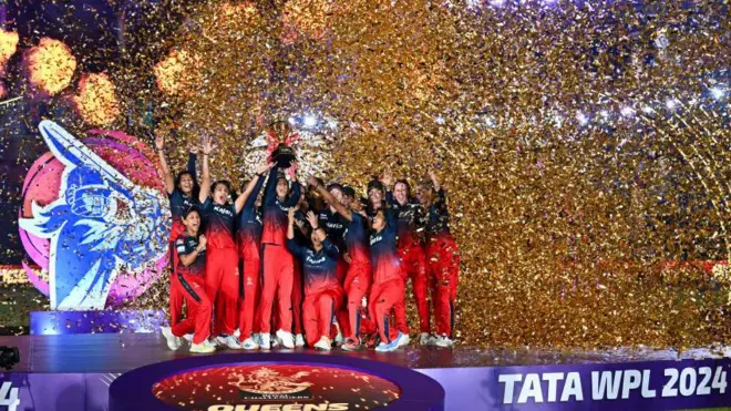 RCB celebrating with trophy of WPL