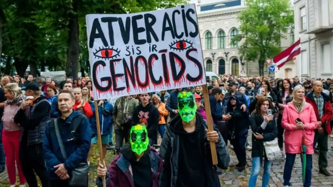 В августе более 5 тысяч латвийцев вышли на демонстрацию против обязательных прививок: "Открой глаза - это геноцид!", - написано на плакате
