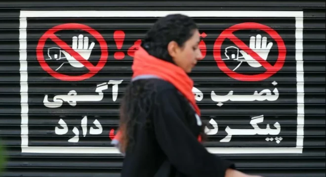 امرأة إيرانية تمشي بجوار متجر مغلق من دون ارتداء الحجاب، في طهران، إيران، 10 أغسطس/ آب 2023