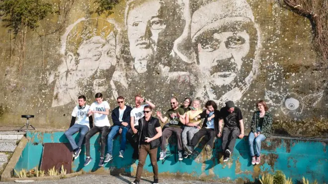 Učesnici projekta i mladi umetniciiz Brčkog ispred završenog murala.