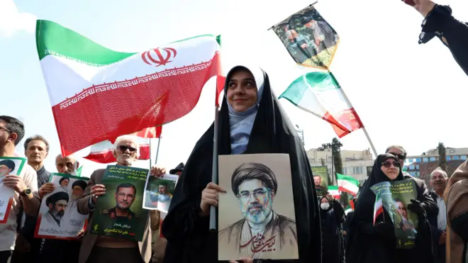 Uma mulher iraniana segura uma foto do supremo líder do Irã, o Aiatolá Mojataba Khamenei. 