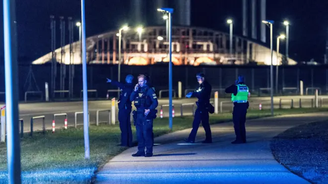 Датские полицейские перекрывают дорогу, на заднем плане видно здание терминала аэропорта