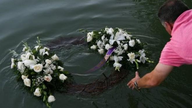 Homem joga coroa de flores na água