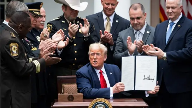 US President Donald Trump shows his signature on an Executive Order on Safe Policing for Safe Communities, in the Rose Garden of the White House