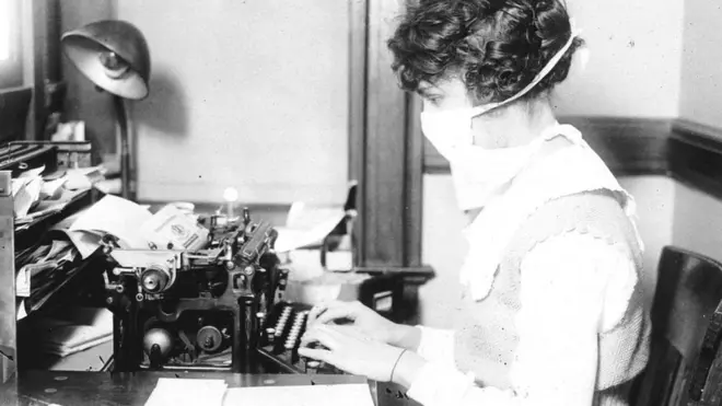 Mujer escribiendo a máquina usando una máscara en 1918.