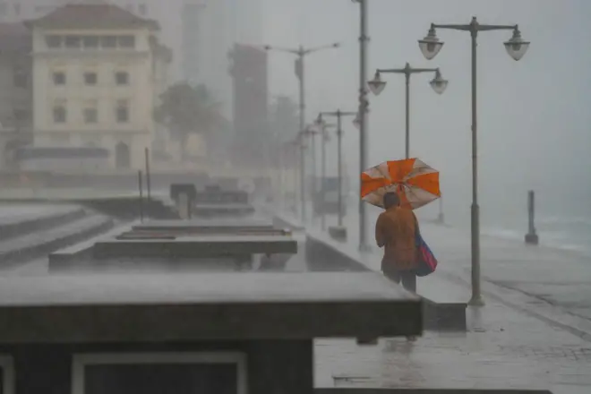 A man holds an umbrella during the heavy rains in Colombo, Sri Lanka, on November 11, 2024. A red warning is issued for severe weather as a low-pressure area intensifies near Sri Lanka