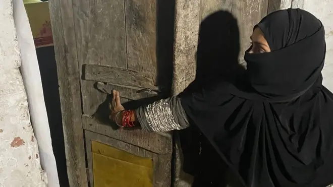 आसिफ़ अली की पत्नी चाँद बी अपने घर का टूटा दरवाज़ा दिखाते हुए