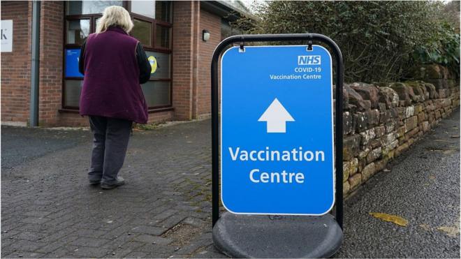 woman walking into vaccination centre