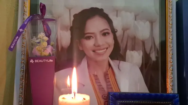 Foto dokter Icha dalam bingkat dengan nyala lilin di depannya dan karangan bunga bertuliskan beauty life.