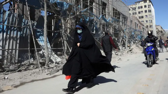 Iranka prolazi pored oštećene zgrade oko Ferdousi trga posle vazdušnog napada u centru Teherana