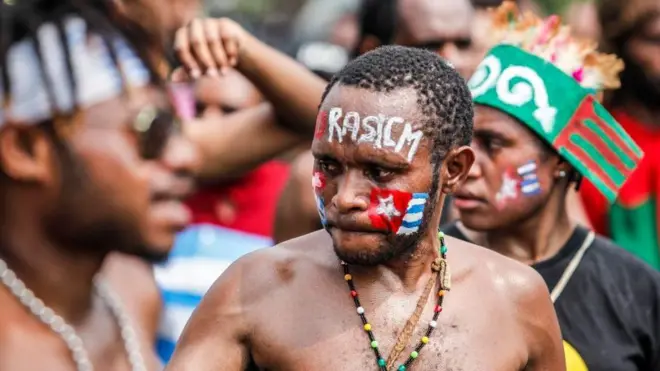 Aktivis Papua mengecat wajahnya dengan warna bendera Bintang Kejora. Ia dan puluhan orang berunjuk rasa untuk menentang rasisme terhadap orang Papua di depan istana presiden di Jakarta, Indonesia, 22 Agustus 2019.