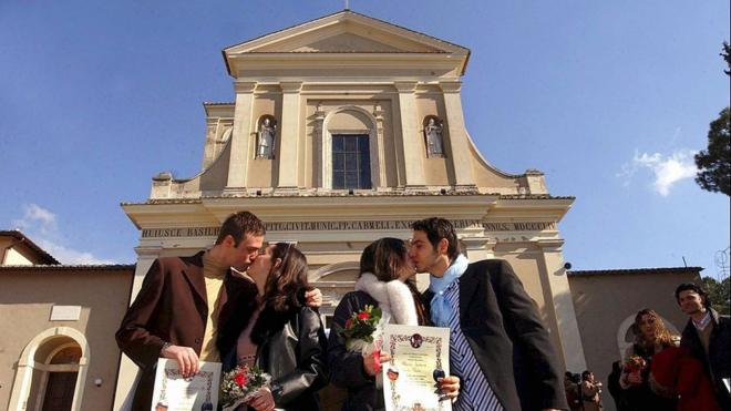 Parejas se besan frente a una iglesia de Terni