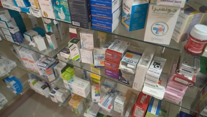 علب من الأدوية المتنوعة مصفوفة على رفوف إحدى الصيدليات