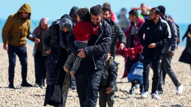 Abantu, bikekwa ko ari abimukira, bagenda ahitwa Dungeness mu Bwongereza, muri Kanama 2023