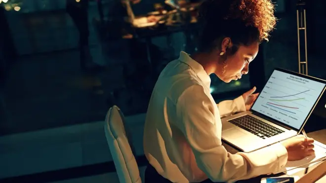 Shot of a young businesswoman working late in her office