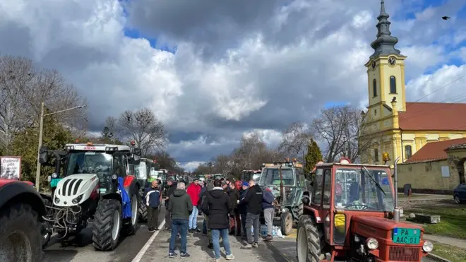 протест пољопривредника, трактори на улици а око њих окупљени људи